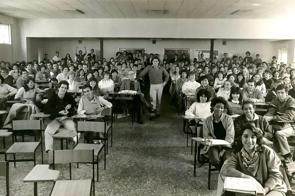 SLU-Madrid 1982 A group of students pose for a photo in a classroom in this black and white image.