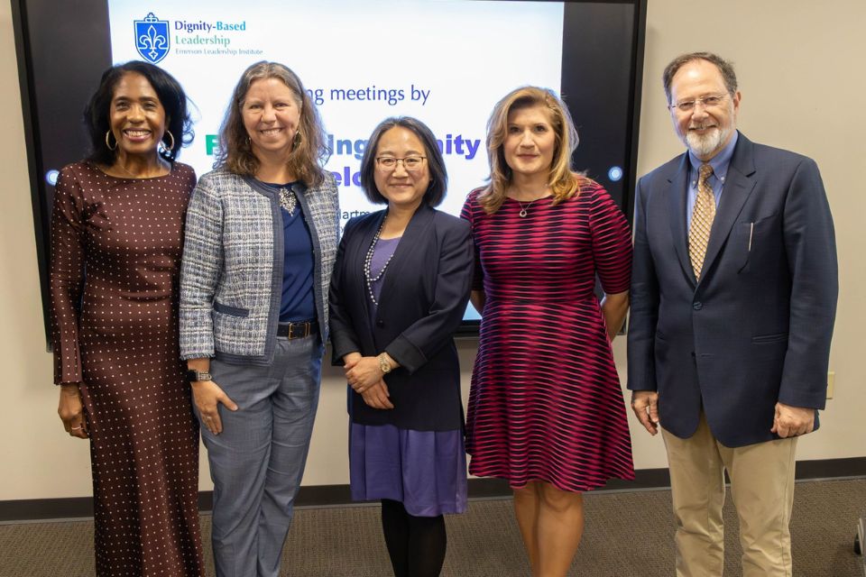 Faculty Development Program 2026 five people stand smiling posed in front of a screen