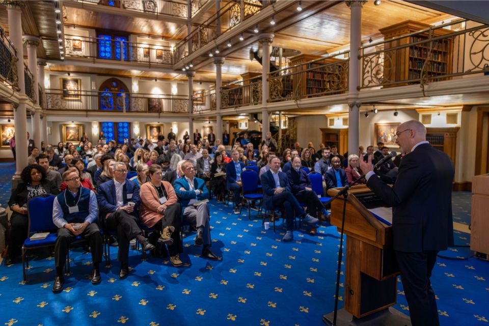 President Feser Speaker Series 2026 a man stands speaking at a podium speaking in front of a crowd of people