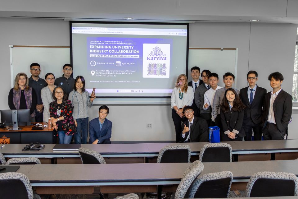 Karviva Case Competition 2026 a group of people stand posed on either side of a projector screen