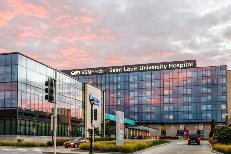 An exterior view of SSM Health Saint Louis University Hospital during sunset.