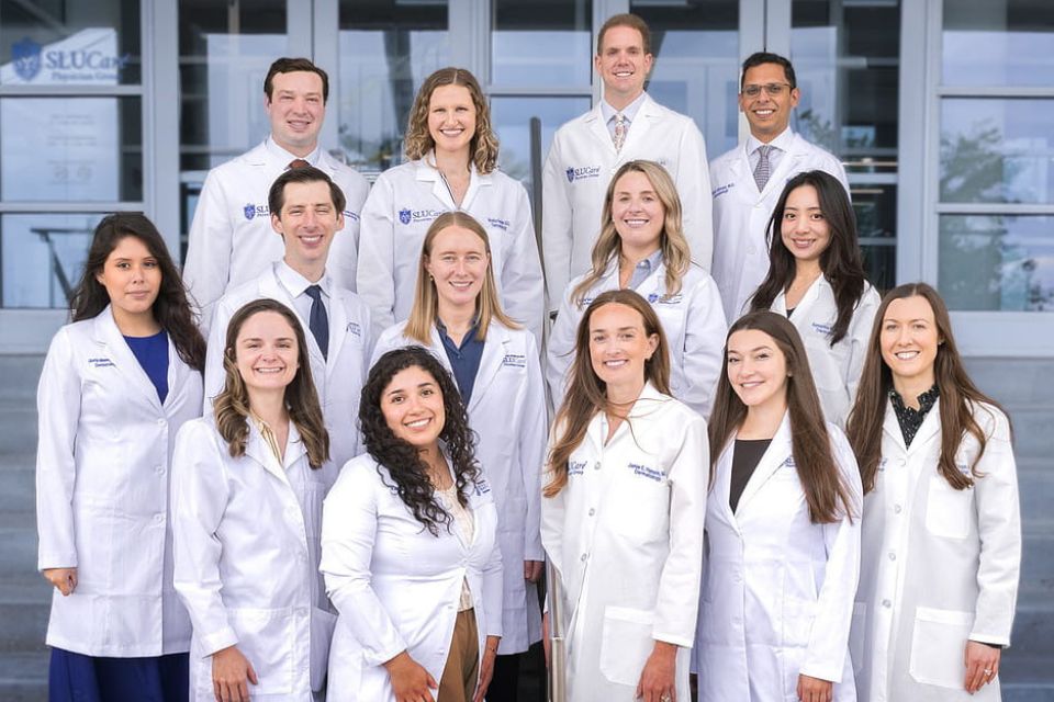 A group photo of the Dermatology residents posing on a set of exterior stairs.