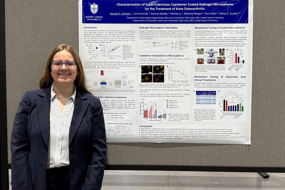 Hannah Johnson, a biomedical engineering student, stands in front of a conference post.